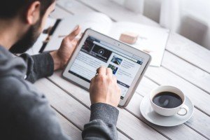 photo of man searching on a tablet for the best resume writing service